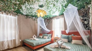 Ein Zimmer mit zwei Betten, jeweils mit Baldachin, und einer dekorativen Decke.