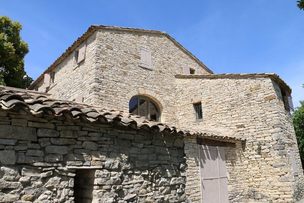 A stone building with a pitched roof, a small arched window, and a door. - Vrbo Property (REVEST SAINT MARTIN)