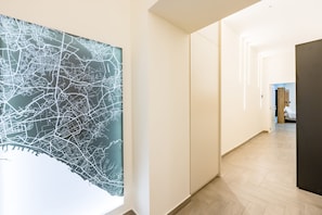 Ein Flur mit einer großen Karte an der Wand, Holzdielen und einer Tür zu einem weiteren Raum.