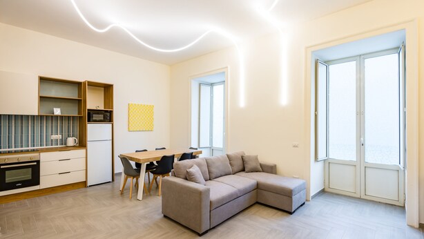 A modern apartment with a kitchen, dining area, and living room. - Solaris Studio - Solaris Suites (Naples)