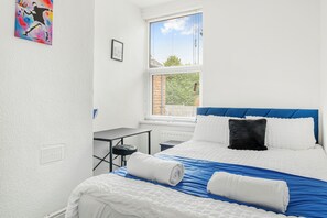 A hotel room with a bed, a window, a desk, and a chair. - NEW! 4BR House, free parking, near City Centre (Nottingham)