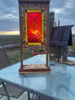A birdhouse with a stained glass window, a feeder, and a small garden area. - Awesome 4-bedroom bed & breakfast in charming Troy, Id. A 360• view, hot tub. (Troy)