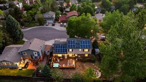 Ein Wohnhaus mit großem Garten, Solaranlage und beleuchtetem Außenbereich.