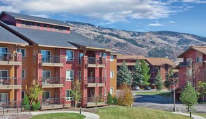 A multi-story residential building with balconies, a parking lot, and a mountainous backdrop. - Relaxing 3 bedroom resort in amazing Steamboat Springs with amenities! (Steamboat Springs)
