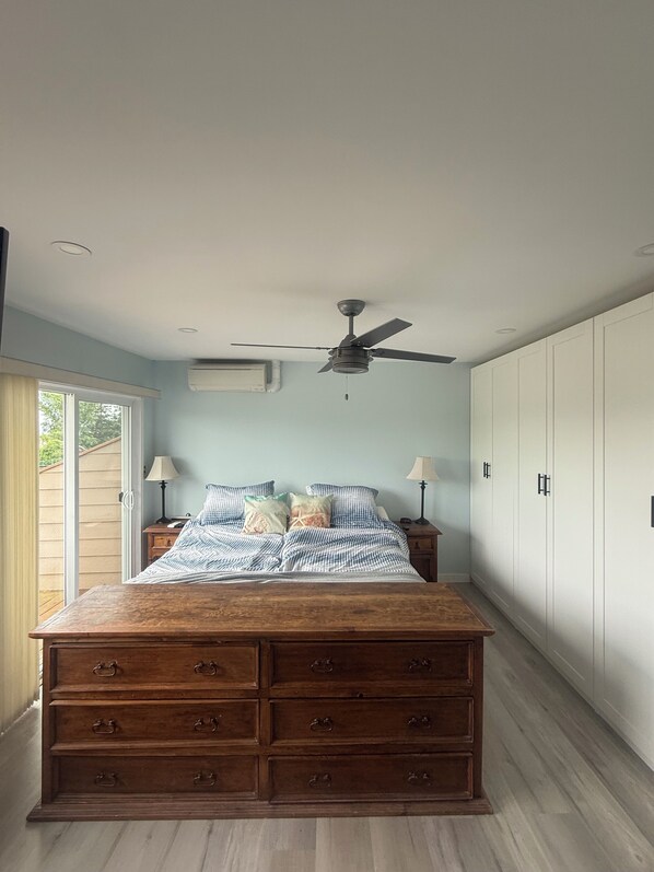 A bedroom with a large bed, a ceiling fan, wooden drawers, and a wardrobe. - Passage view 2,0
Close to beaches and shopping, pet friendly and family friendly (Campbell River)