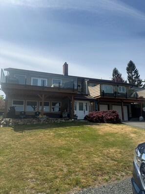 A two-story house with a covered porch, a garage, and a stone retaining wall. - Passage view 2,0
Close to beaches and shopping, pet friendly and family friendly (Campbell River)