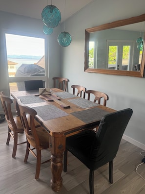 A dining area with a wooden table, chairs, and a large mirror on the wall. - Passage view 2,0
Close to beaches and shopping, pet friendly and family friendly (Campbell River)