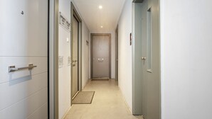 Un pasillo con puertas que dicen 'Infinity Suite' y 'Deluxe Suite', un felpudo y un accesorio de iluminación en el techo.