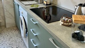 A compact kitchen with a built-in washing machine, a sink, and a stove. - A Due Passi Dalla Certosa via Guglielmo Marconi 12, Certosa di Pavi (Certosa di Pavia)