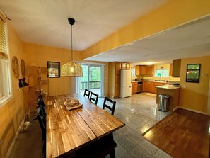 Eine geräumige Küche mit Holzschränken, einem Kühlschrank und einem Essbereich mit Holztisch und Stühlen.