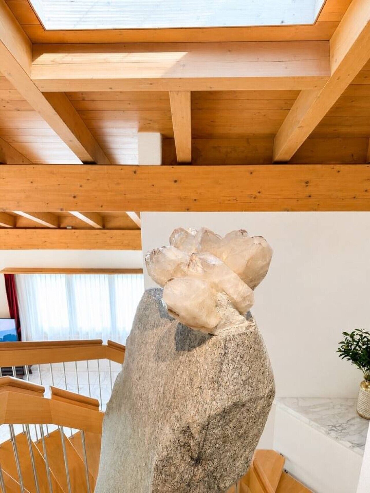 A wooden staircase with a large rock sculpture.