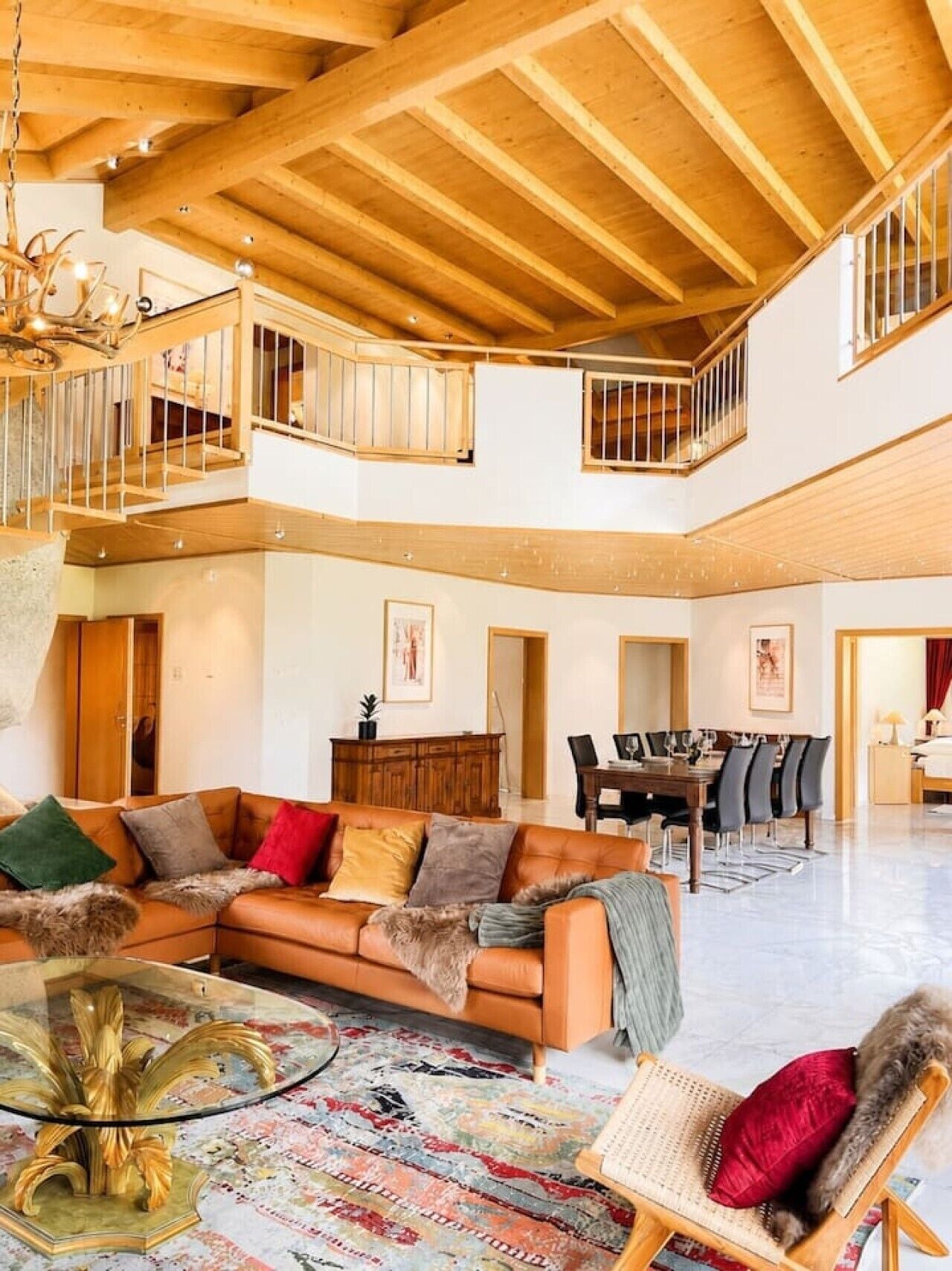 A spacious living area with a high ceiling, a dining table, and a comfortable seating arrangement.