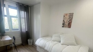 Um quarto com uma cama, uma mesa e uma cadeira.