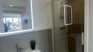 Een douche, een haardroger, een bidet, handdoeken