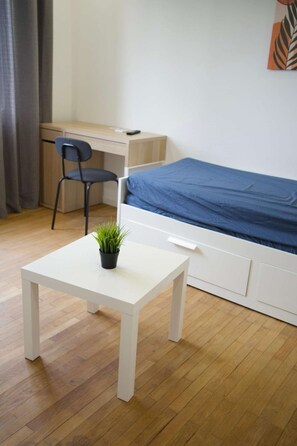 A room with a bed, a desk, a chair, and a small table with a plant. - Cozy Private Room | Coliving 30min from Paris St-Lazare (Argenteuil)