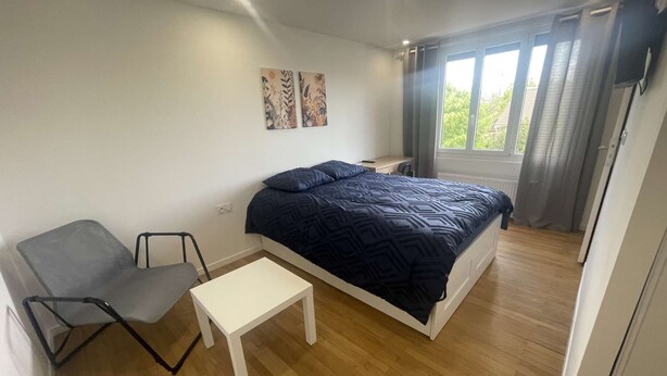 A bedroom with a bed, a desk, a chair, and a window with curtains. - Cozy Private Room | Coliving 30min from Paris St-Lazare (Argenteuil)