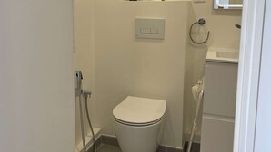 A small, clean bathroom with a toilet, a shower, a sink, and a mirror. - Cozy Private Room | Coliving 30min from Paris St-Lazare (Argenteuil)