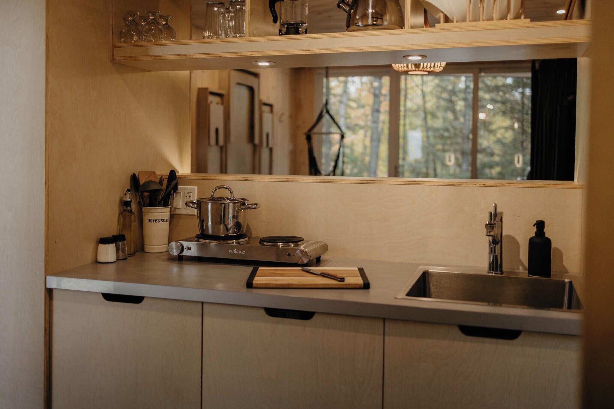 Une cuisine équipée d’une cuisinière, d’un évier et de meubles de rangement en bois.