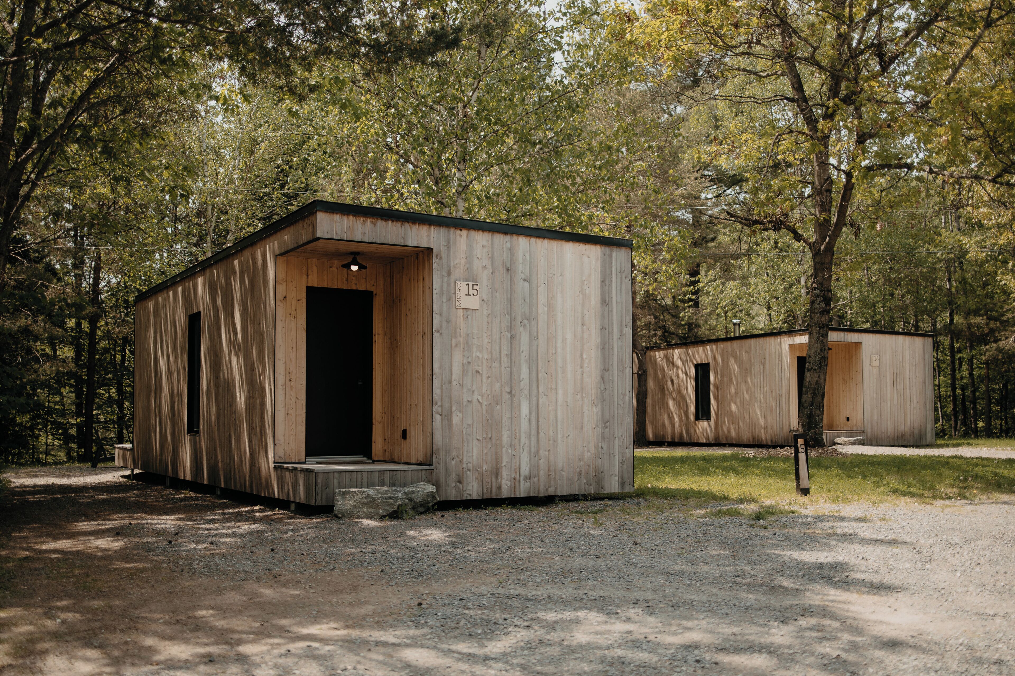 A wooden cabin with a door, a window, and a number sign.
