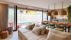 A modern living room with a sofa, dining table, and chairs.