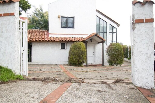 A white building with a tiled roof, a small window, and a door. - Amplia Casa en Reñaca Para 10 Personas (Vina del Mar)