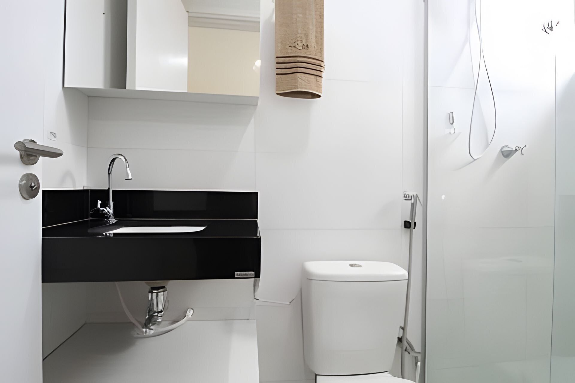 A modern bathroom with a black sink, white toilet, and a shower area.
