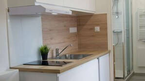 Una cucina moderna con piano cottura integrato, lavello e schienale in legno.