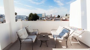 A balcony with two chairs, a small table, and a drying rack. - SerenityOne - Centrally located Apt,SO19 (Agia Napa)
