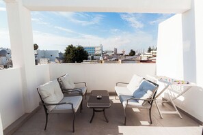 A balcony with two chairs, a small table, and a drying rack. - SerenityOne - Centrally located Apt,SO19 (Agia Napa)