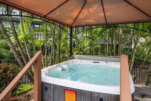 A hot tub under a canopy surrounded by tropical plants. - Kona Islander Inn#336 (Kailua-Kona)