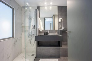 A modern bathroom with a glass-enclosed shower, a large mirror, and a dark-toned sink. - Cozy Spacious Studio Psyri AcropolisView (Athina)