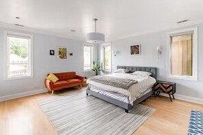 A bedroom with a bed, a sofa, a rug, and a nightstand. - Huge Lakeview Retreat near Wrigley Field with mutliple balconies (Chicago)