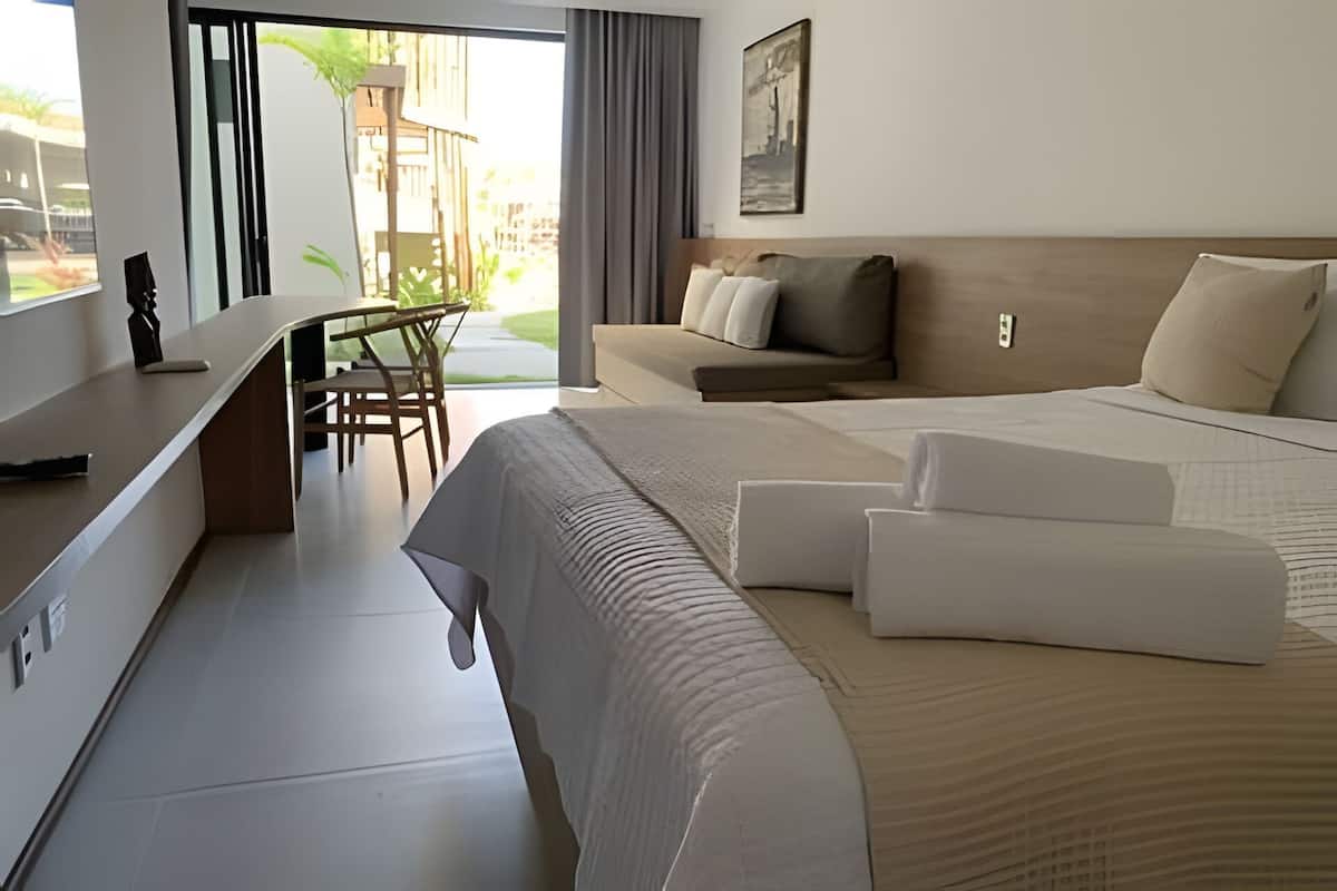 Une chambre d’hôtel avec un lit, un canapé, un bureau et une chaise.
