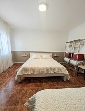 Ein Schlafzimmer mit einem Bett, einem Nachttisch, einem Kleiderschrank und einem Fenster mit Vorhängen.