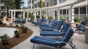 A covered outdoor seating area with multiple lounge chairs and a pergola structure. - Myrtle Beach Family Escape with Spacious 3BR Lockoff Resort Suite (Myrtle Beach)