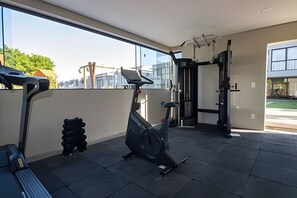 Ein Fitnessstudio mit Trainingsgeräten, Laufband und Kraftmaschine.