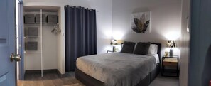 A bedroom with a bed, bedside tables, a wardrobe, and a curtain. - Blue Morpho Casita Private Pool & Volcano View minutes from downtown La Fortuna  (La Fortuna)