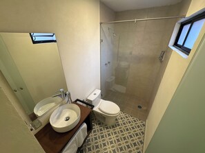 Un baño con lavabo, inodoro y ducha.