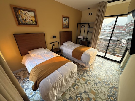 A hotel room with two beds, a window with a view, and a painting on the wall.. HOTEL POSADA DE PIEDRA