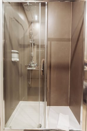A glass-enclosed shower stall with a handheld showerhead, a handheld showerhead, and a wall-mounted soap dispenser. - Views from the Villa_ Deluxe Double Room (12) w/ private bathroom (Cabeceiras de Basto) (Cabeceiras de Basto)