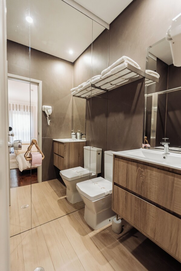 A modern bathroom with a glass partition, a wooden vanity, a white toilet, and a towel rack. - Views from the Villa_ Deluxe Double Room (12) w/ private bathroom (Cabeceiras de Basto) (Cabeceiras de Basto)