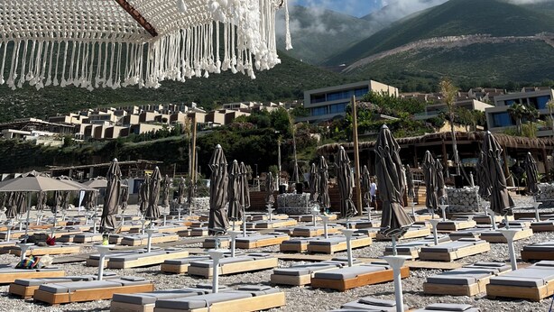 A beachside hotel with a macrame canopy, sun loungers, and a mountainous backdrop. - Cosy apartment in Green Coast Albania-blue flag beach (Palasë)