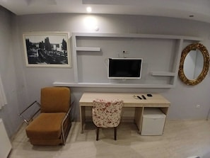A room with a bed, a desk, a chair, a television, and a mirror. - PERA CITY OTEL (Samsun)