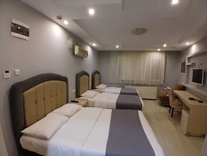 A hotel room with two beds, a desk, a chair, a TV, and a window with curtains. - PERA CITY OTEL (Samsun)