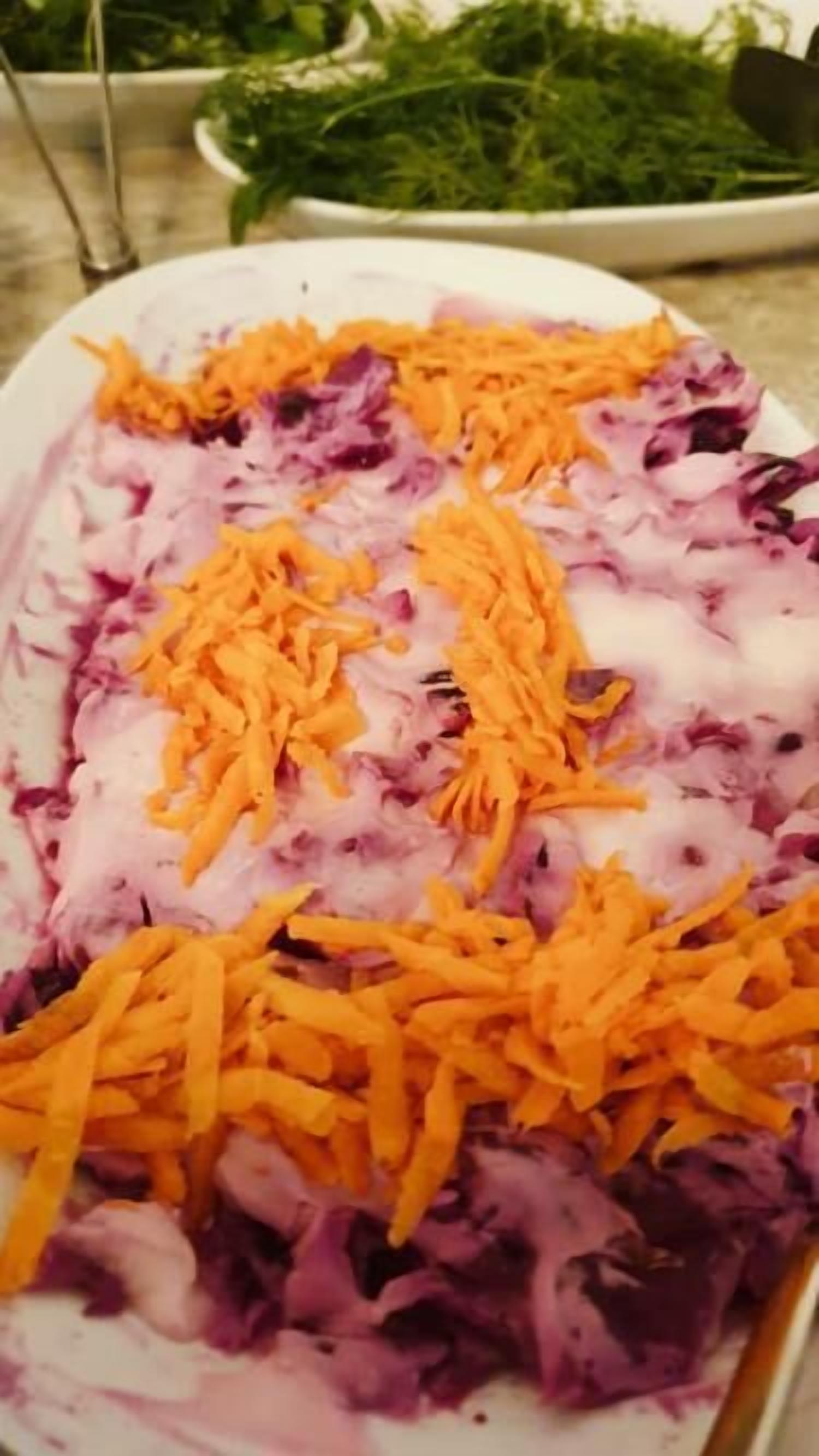 Un plato con vegetales morados y naranjas rallados.