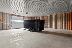 A large, empty warehouse with a black trailer, metal walls, and a concrete floor. - Awesome barn retreat in welcoming Seattle for a unique stay (Seattle)