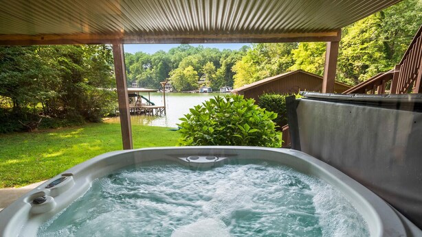 Ein Whirlpool mit Blick auf einen See und umliegendes Grün.
