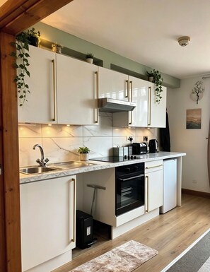 Eine moderne Küche mit weißen Schränken, einem eingebauten Backofen und einer Marmor-Spritzschutzwand.