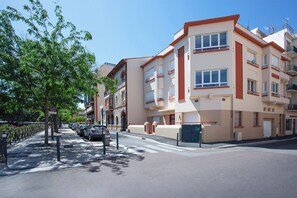 A multi-story residential building with balconies, a gated entrance, and a clear sky. - Le Bourdon - Terrasse - Centre-ville (Perpignan)