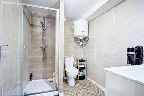 Ein Badezimmer mit Dusche, Toilette und Badewanne.